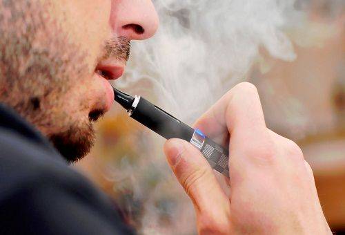 cilvēks smēķē elektronisko cigareti