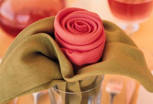 Napkins folded with a rose in a glass