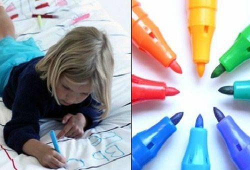 little girl draws with felt-tip pens