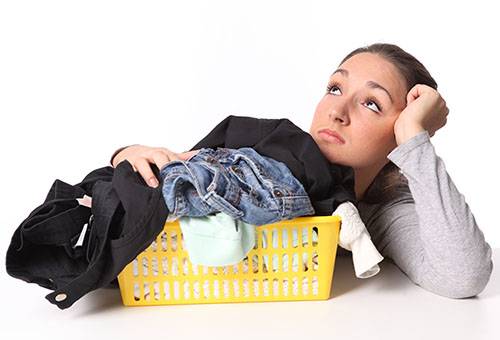 Girl thinks how to wash jeans and trousers.
