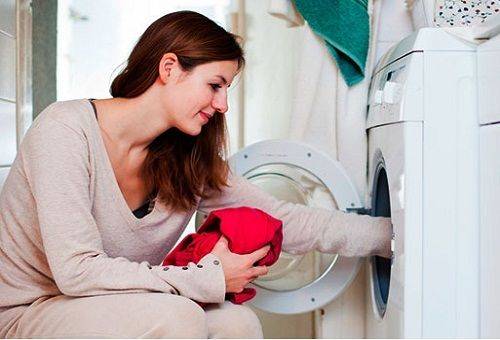 woman puts laundry in a car