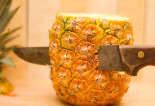peeling pineapple with a knife