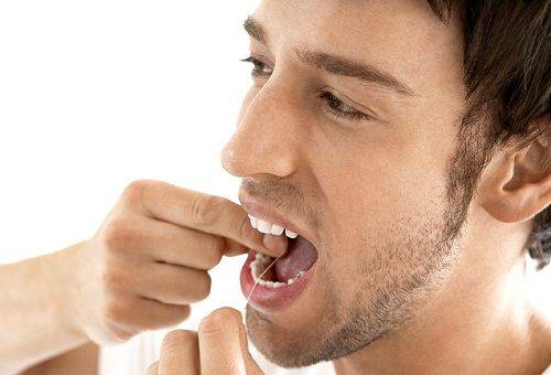 man flossing his teeth