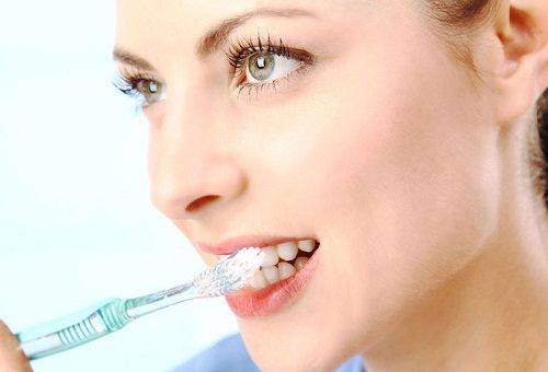 woman brushes her teeth