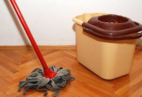 girl cleans the floor with a rag