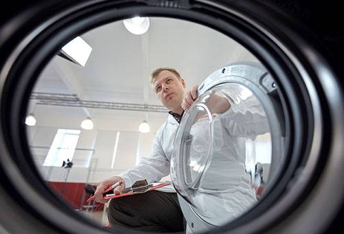 A man is studying a washing machine