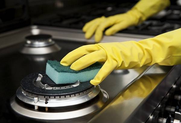 woman cleans the stove