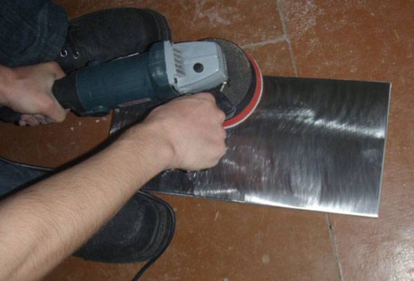 Removing old paint from a metal sheet with a grinder
