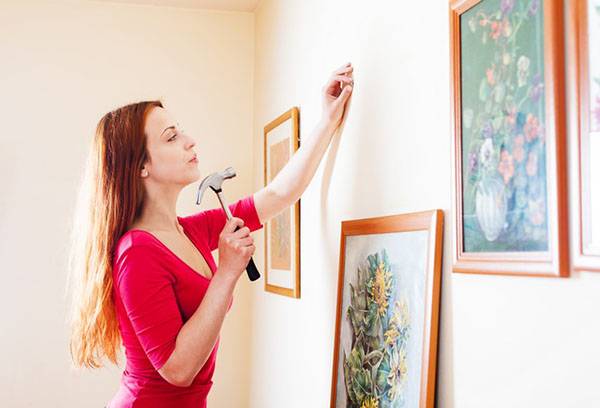 Girl hangs pictures