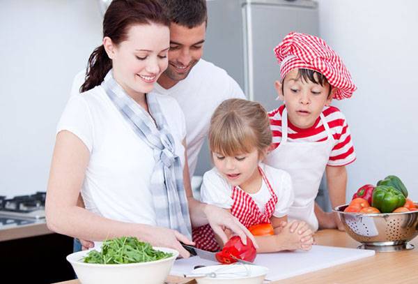 Family in the kitchen preparing a salad