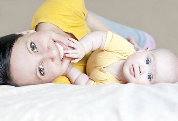 Mamma ar bērnu uz gultas bez spilvena