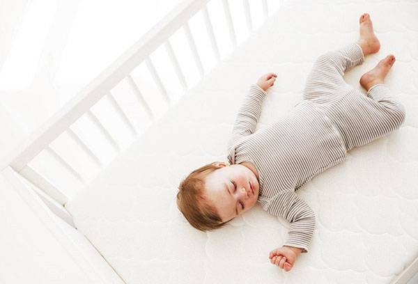 Toddler sleeping in a crib