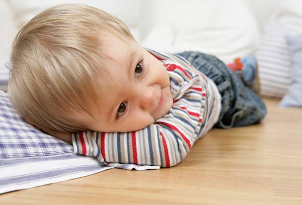 The child lies on the floor