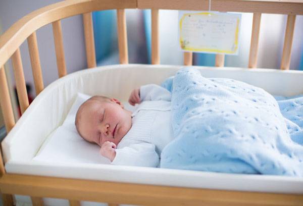 Baby in the crib under the covers