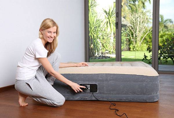 Girl inflates a mattress for sleeping