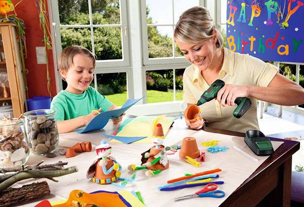 Mom with a child glue crafts with a thermal gun