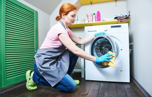 Girl cleans a washing machine