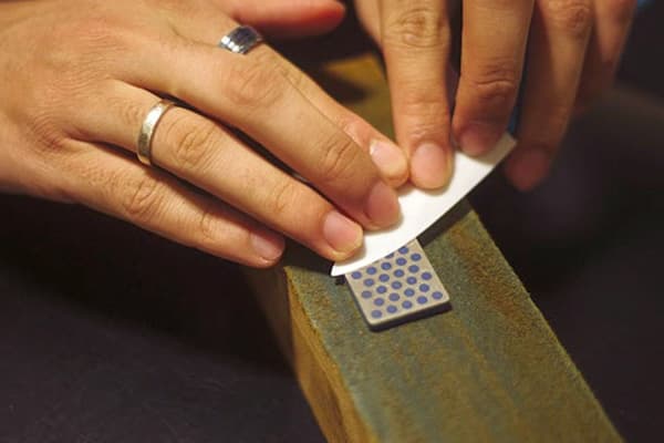 Sharpening a ceramic knife on a grindstone