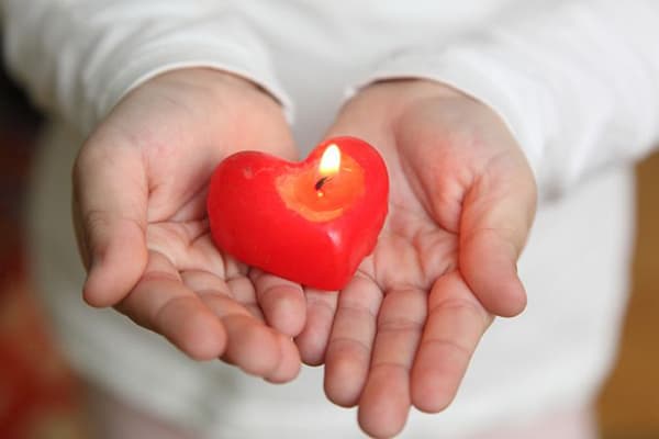 Burning candle in hands