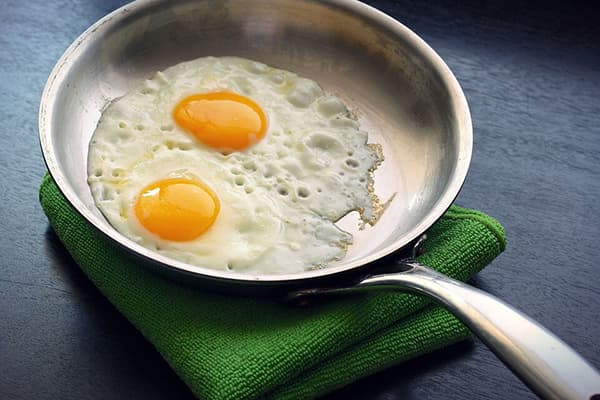Fried eggs in an aluminum pan