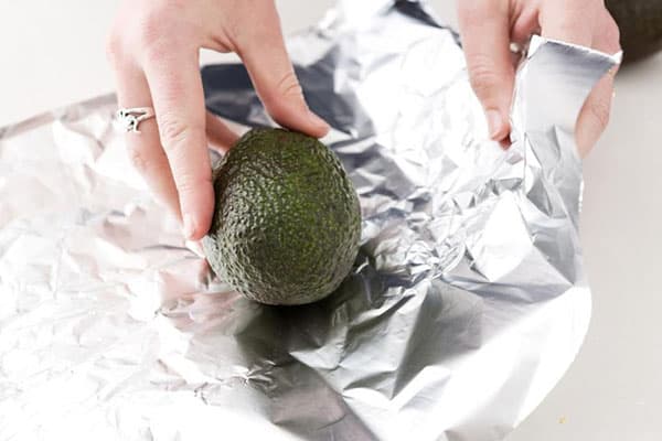 Woman wraps avocado in foil