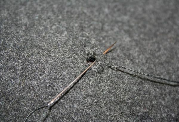 Repairing clothes with a needle and thread