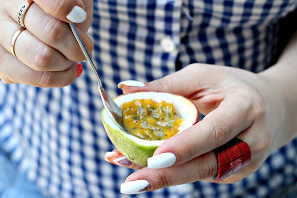 Woman eating passion fruit