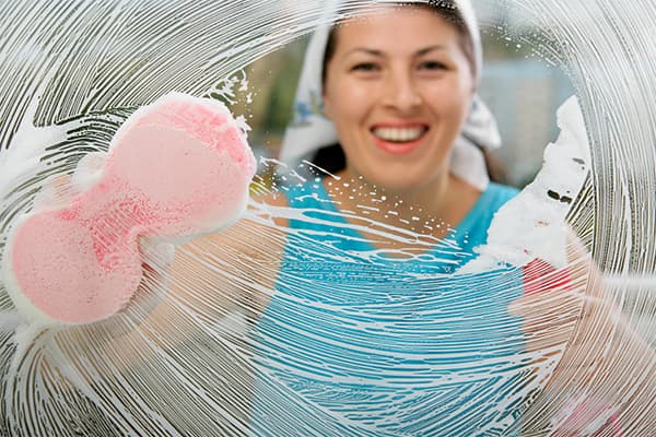 Woman washes a window