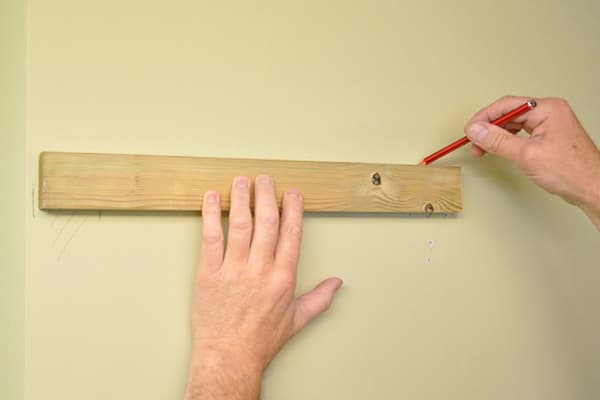 Marking the wall under the shelf