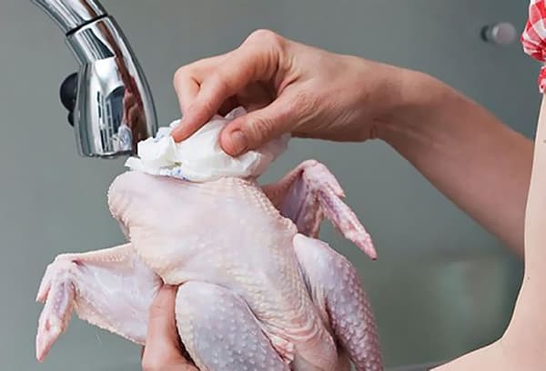 Blotting chicken with a paper towel