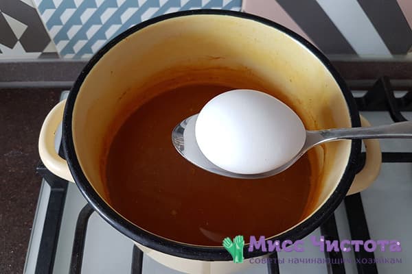 Dipping eggs in turmeric broth