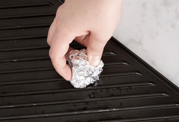 cleaning the barbecue with a foil ball
