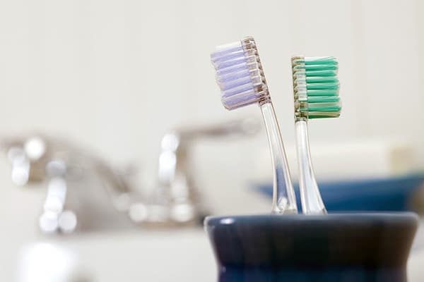 Two toothbrushes in a cup