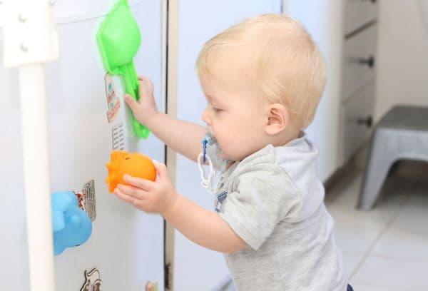 Playing child by the fridge