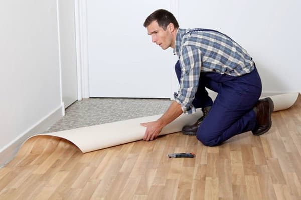 A man weaves a new linoleum on an old
