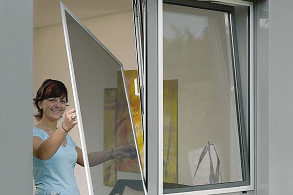 Woman removes the net from the window