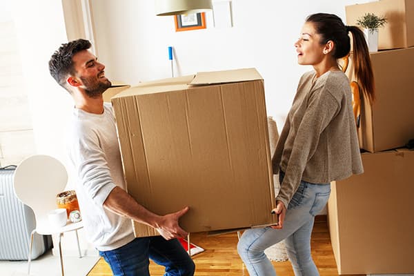 A man and a woman carry a large box