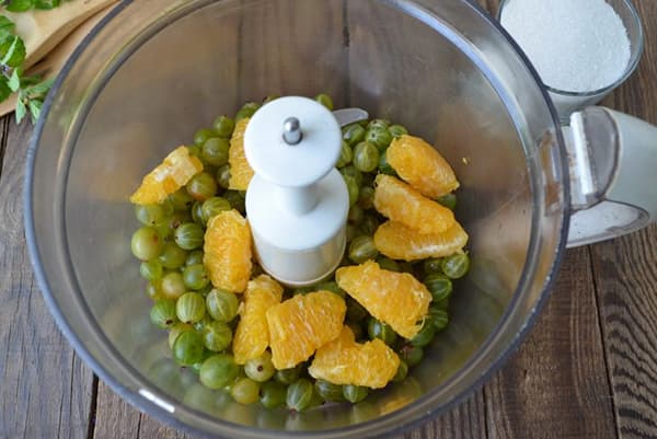 Gooseberries and orange in a blender bowl