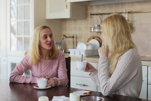 Women drink tea in the kitchen