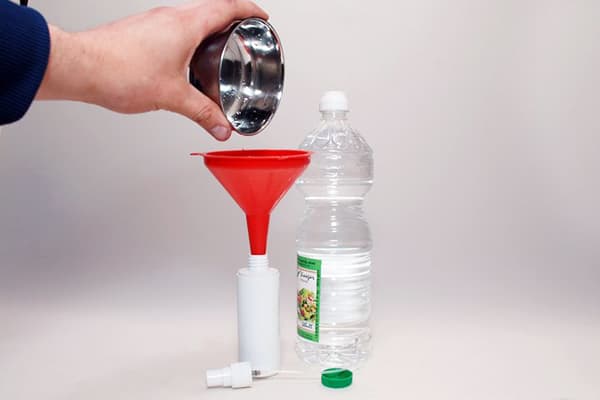 Pouring vinegar into a plastic bottle