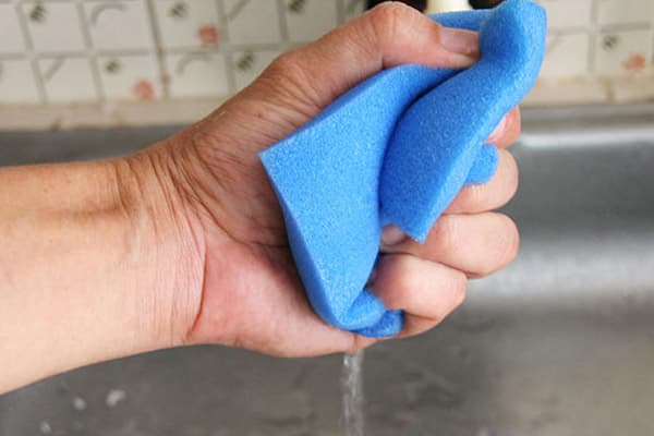 A man presses a foam sponge