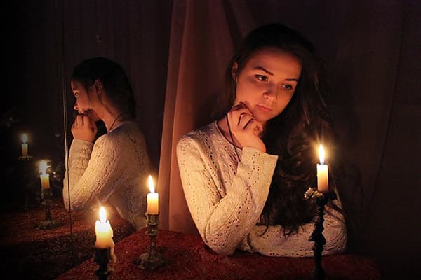 Girl sitting at the mirror with candles
