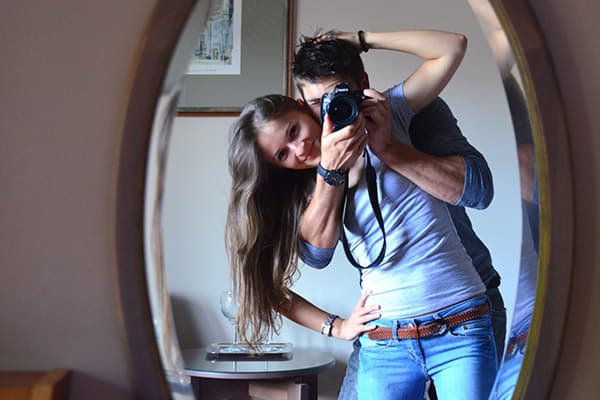 Young couple taking pictures in front of a mirror