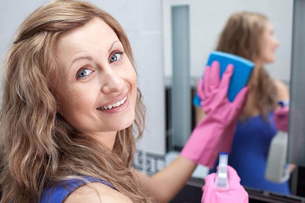 Woman washes a mirror