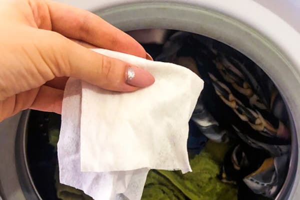 Woman puts a wet towel in a washing machine