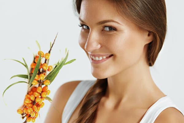 Girl with a branch of sea buckthorn