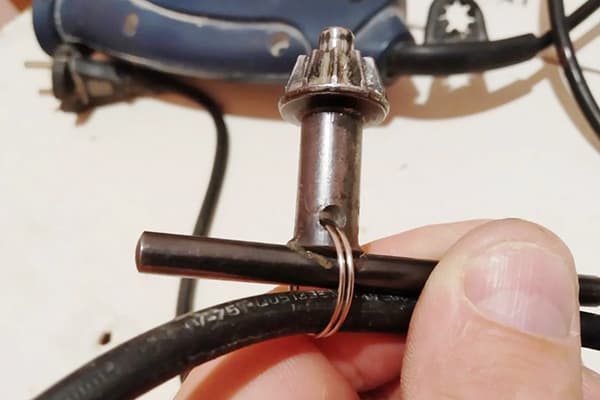 Fastening the key from the drill to the wire with a metal ring