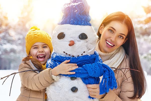 Mom with daughter sculpt a snowman