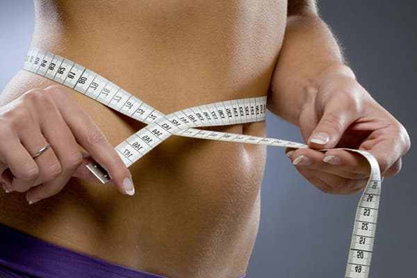 Slender girl measures the waist